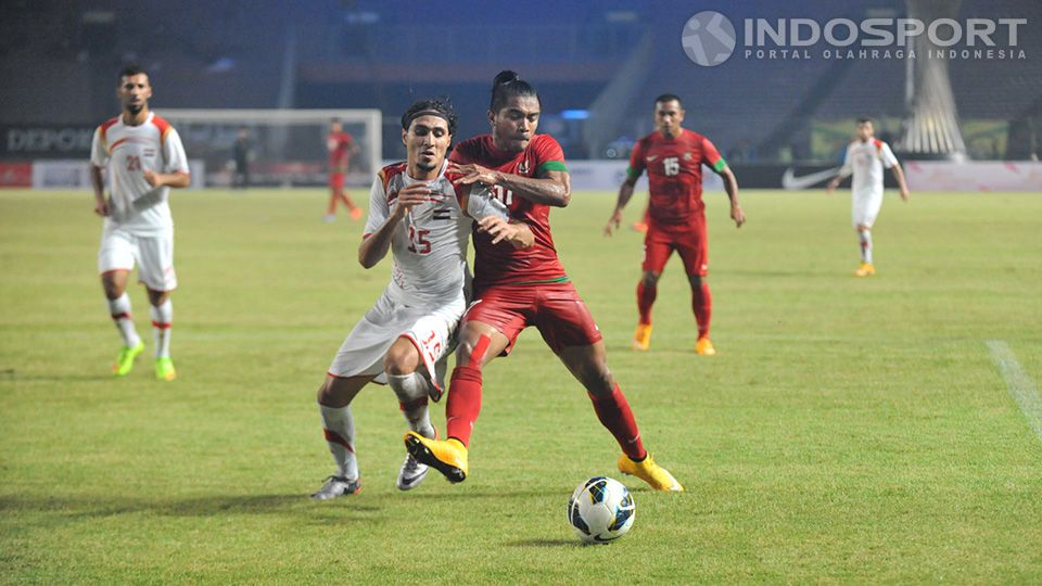 Zulham Zamrun, Sabtu (15/11/14), mencoba menembus pertahanan ketat Suriah yang dikawal Alaa Alshbbli. Copyright: &copy; Ratno Prasetyo/INDOSPORT